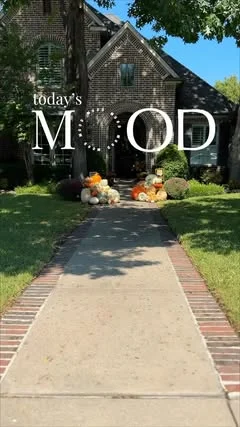 A brick home's front walk with pumpkins at the door