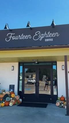 A fall pumpkin install at the entrance of Fourteen Eighteen Coffee