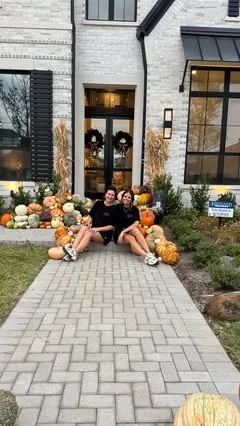Lesli and Casey sitting on a finished front walk